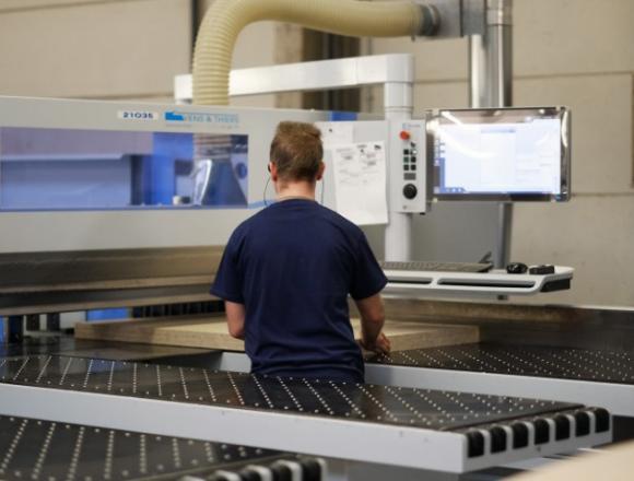 Operator bij opdeelzaag houtbewerking.